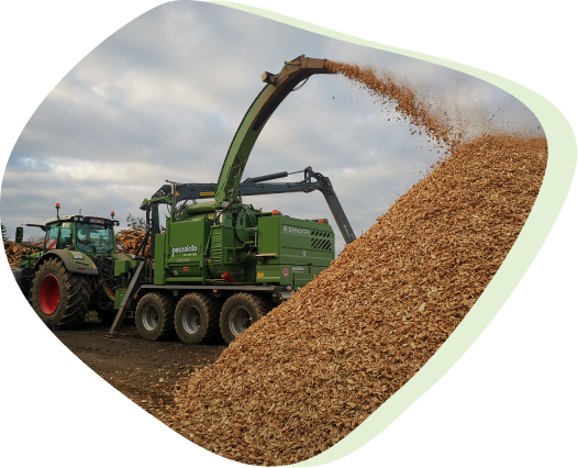 Une machine tirée par un tracteur, qui broie des copeaux de bois